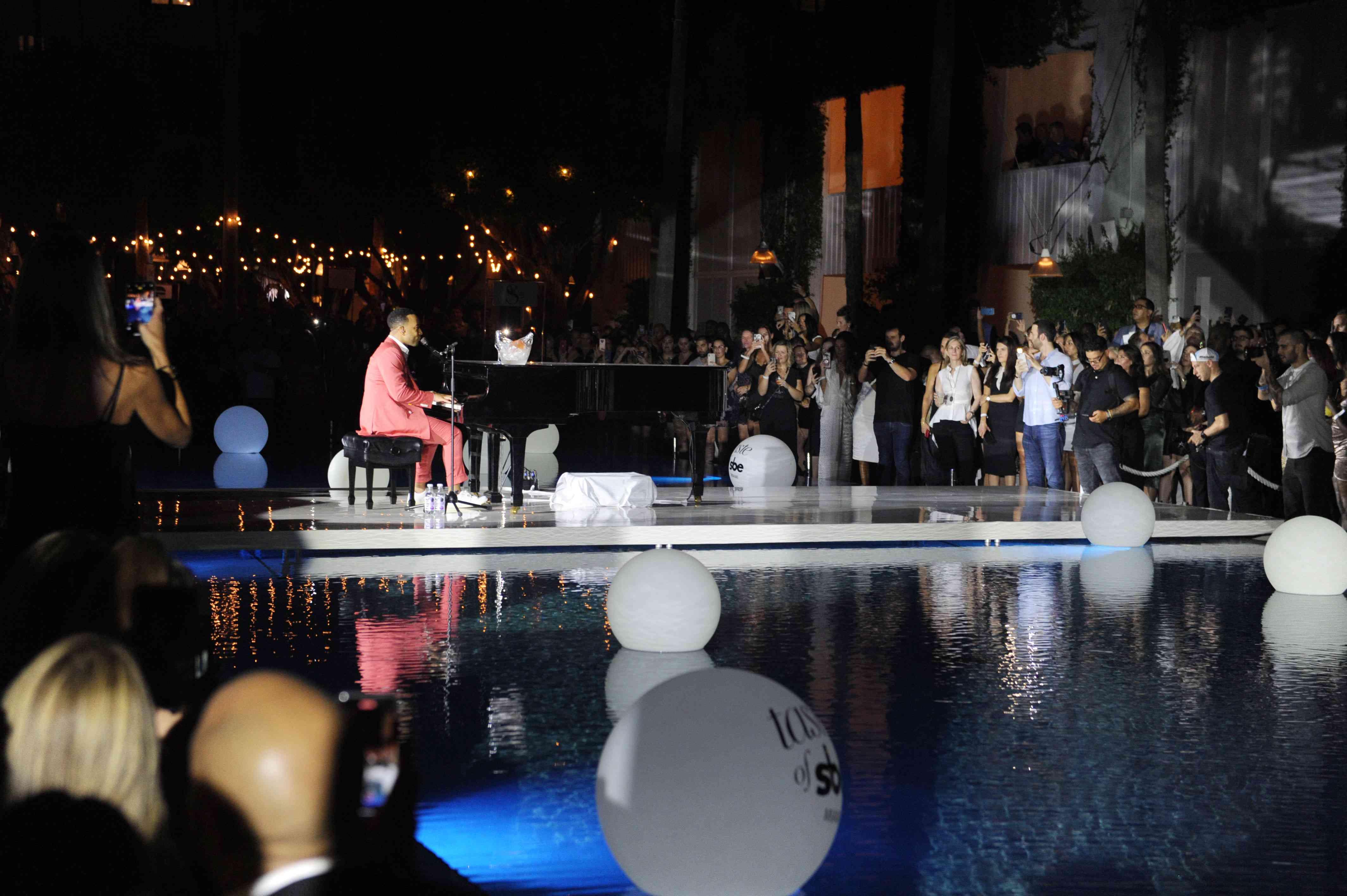 John Legend ao piano à beira da piscina